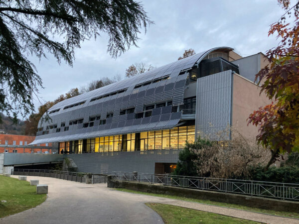 Soir d'automne, la façade solaire se repose laissant deviner les rayonnages de la bibliothèque universitaire. / Agence Beffre