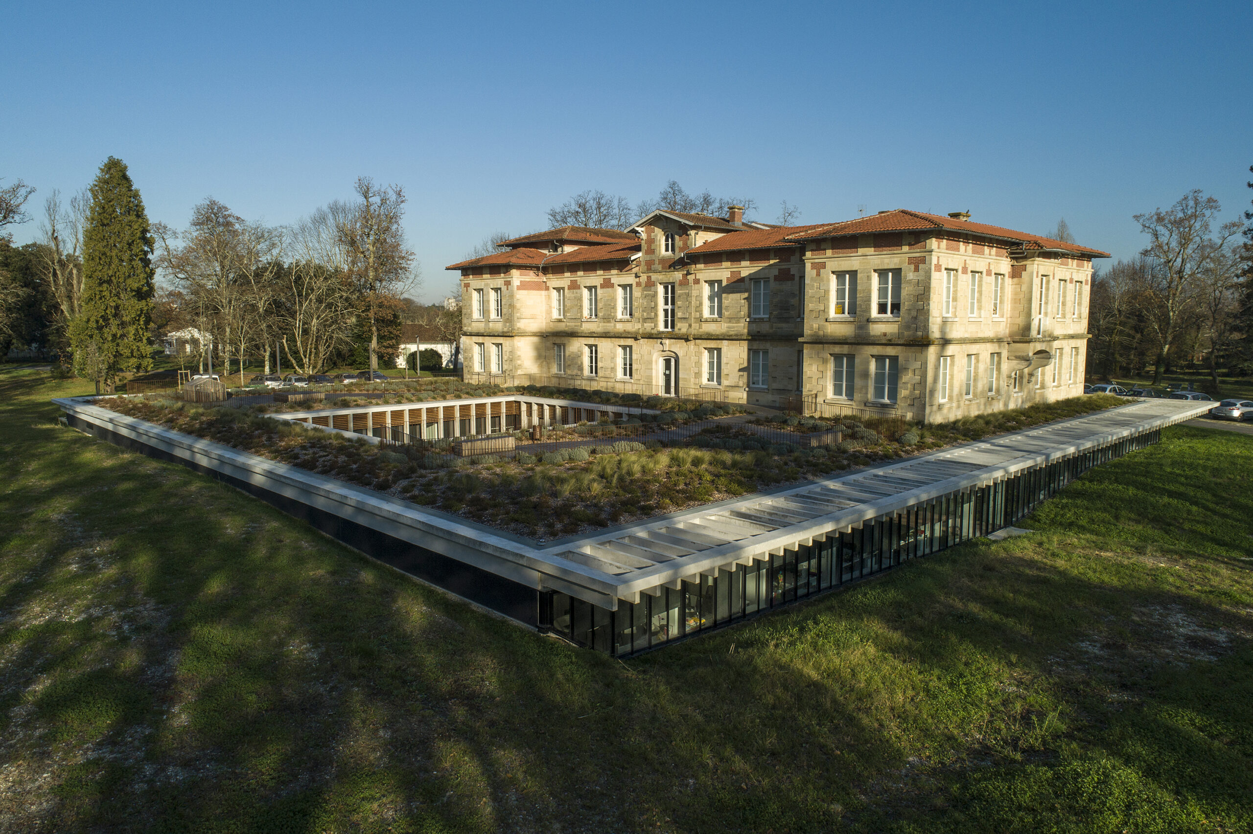l'extension s’ouvre sur les talus végétalisés en façade et sur un généreux patio intérieur / Philippe Caumes